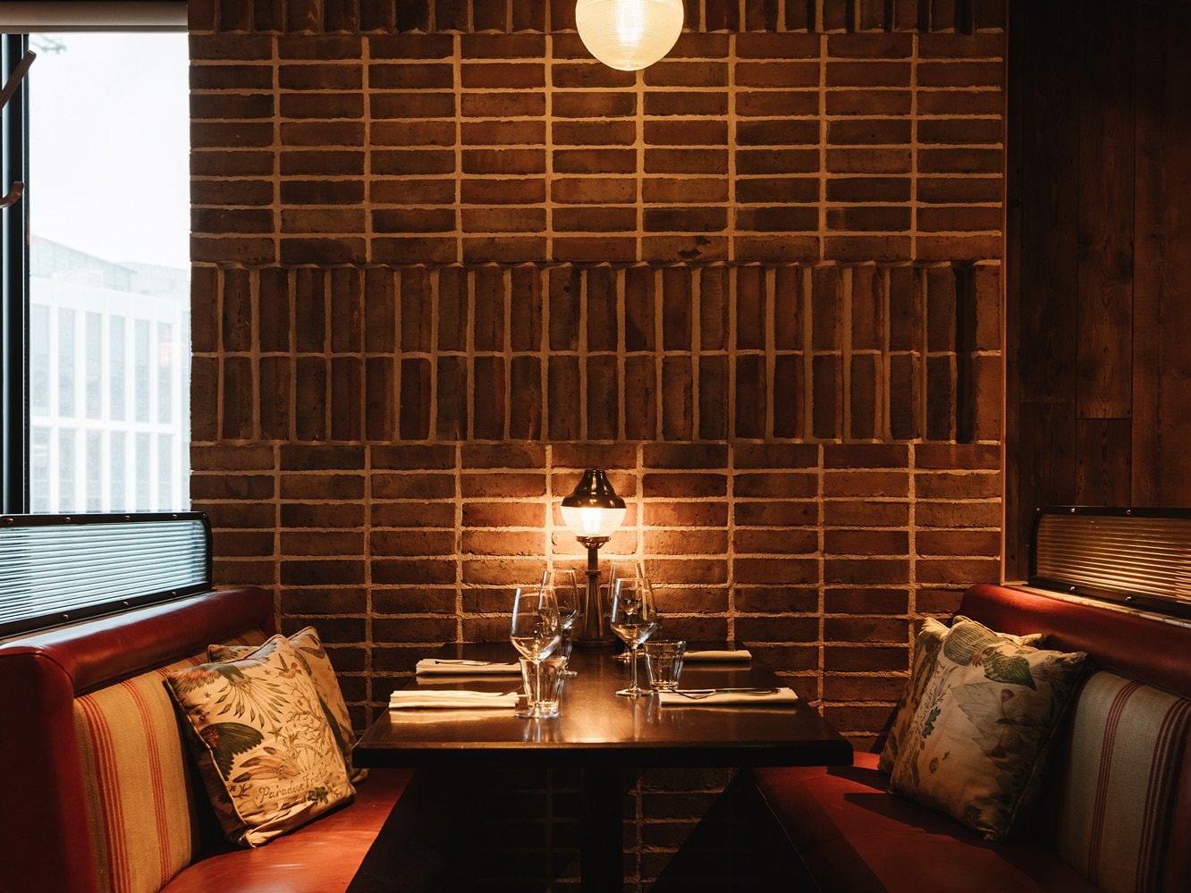 Booth seating next to a brick wall at Sophies