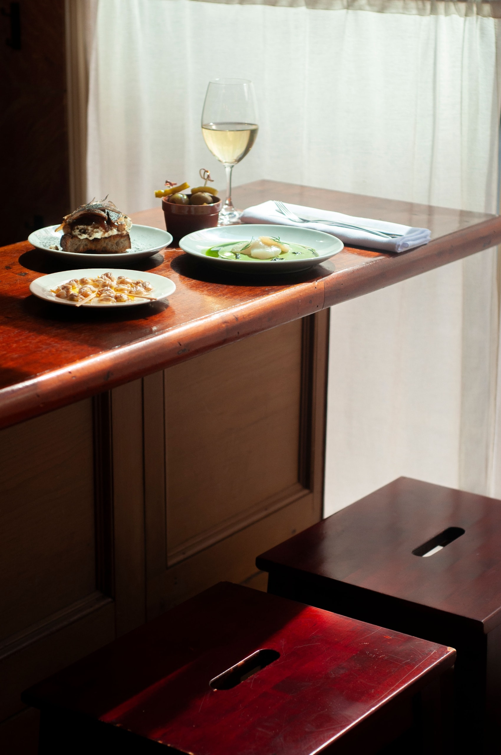 A wooden bar area with food and wine