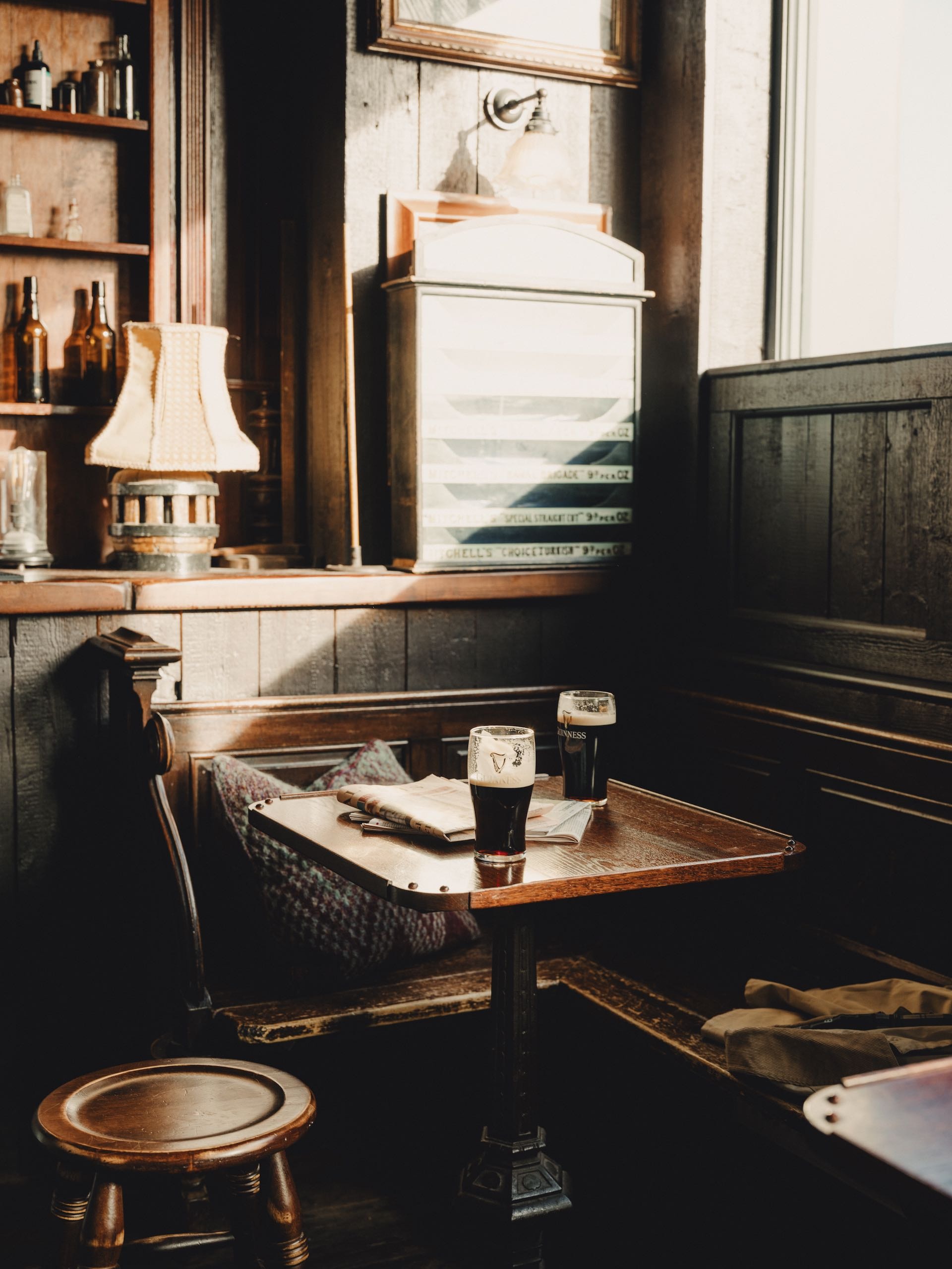 Empty booth at a pub with two dark beer on the table