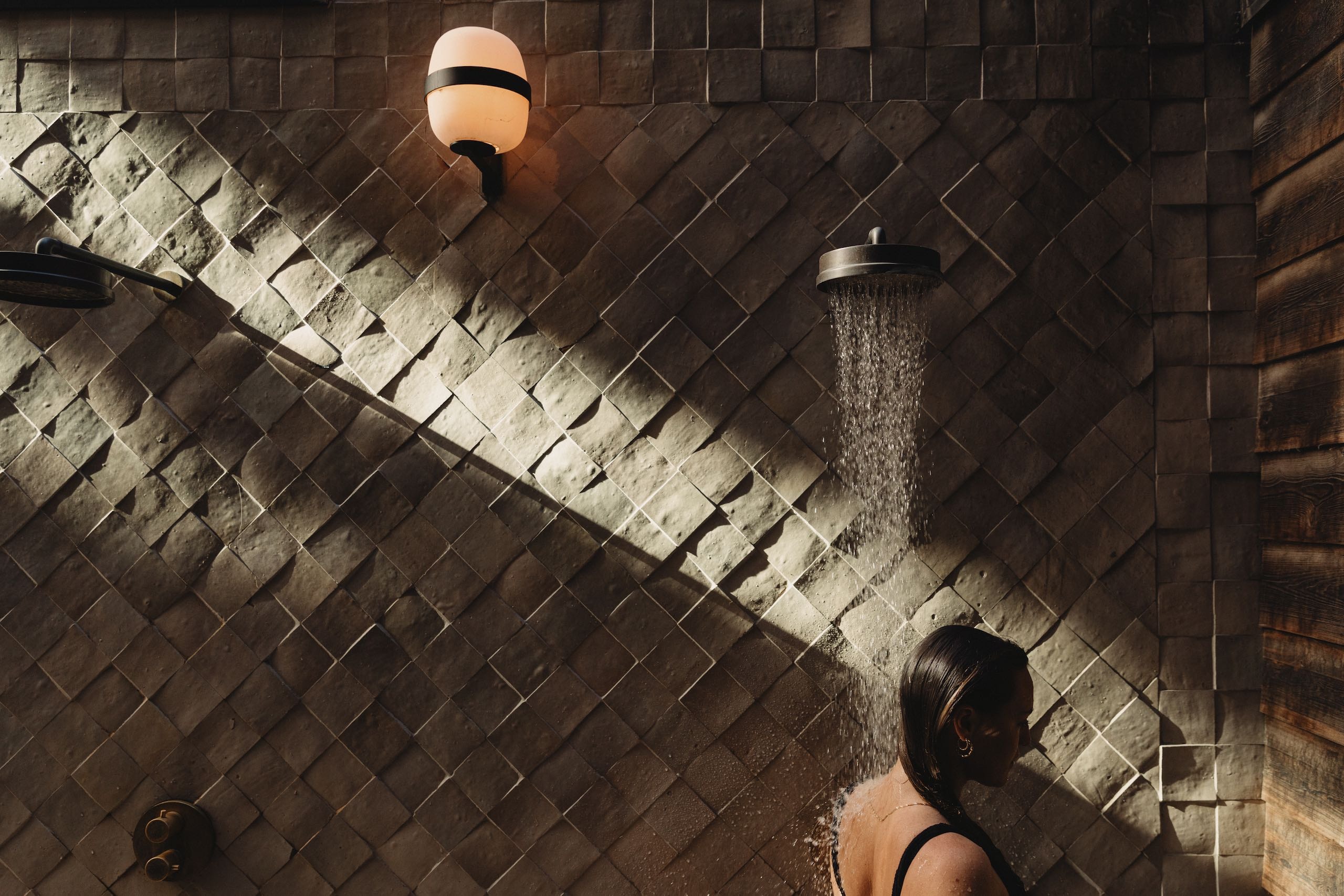 A woman taking a shower in her bathing suit