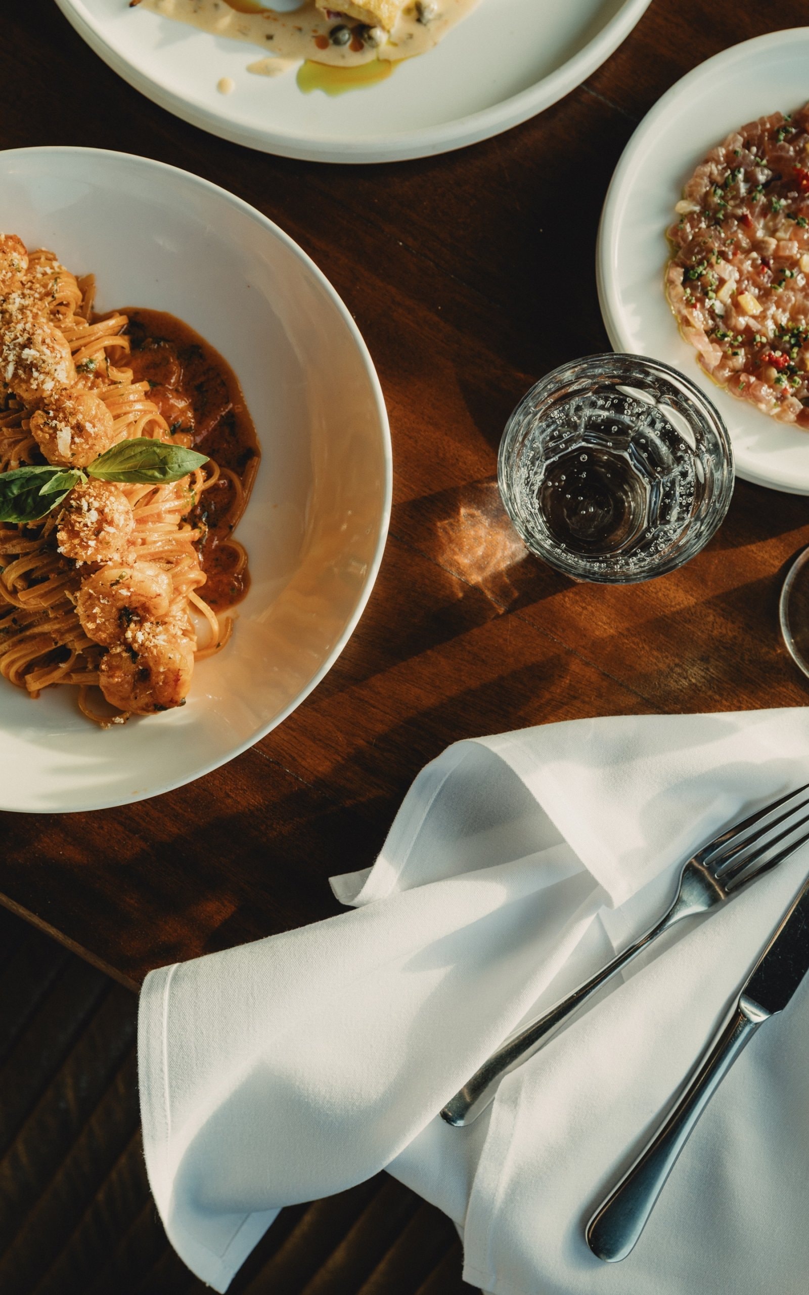 Table with pasta and water glass