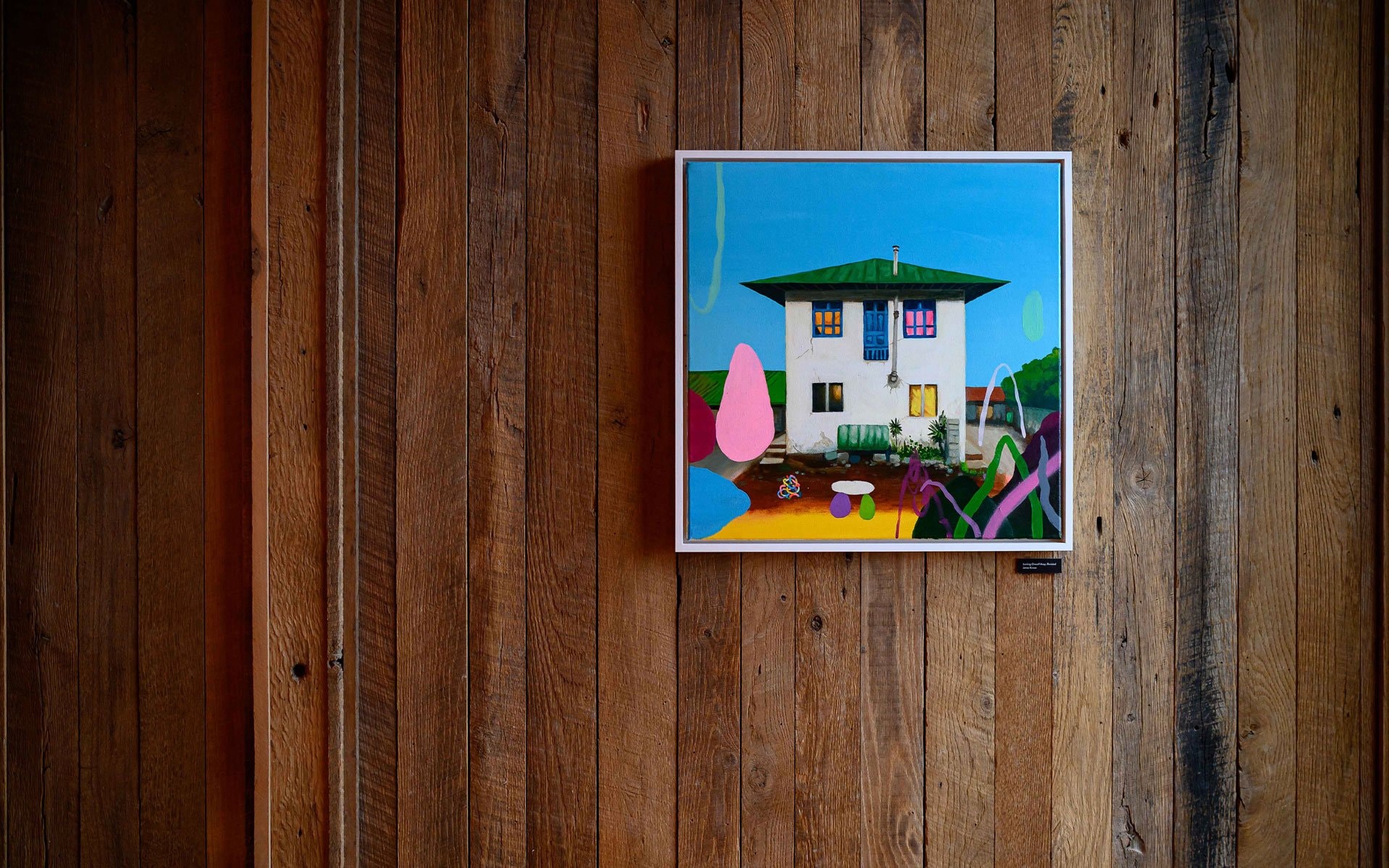 A framed painting on a wood wall