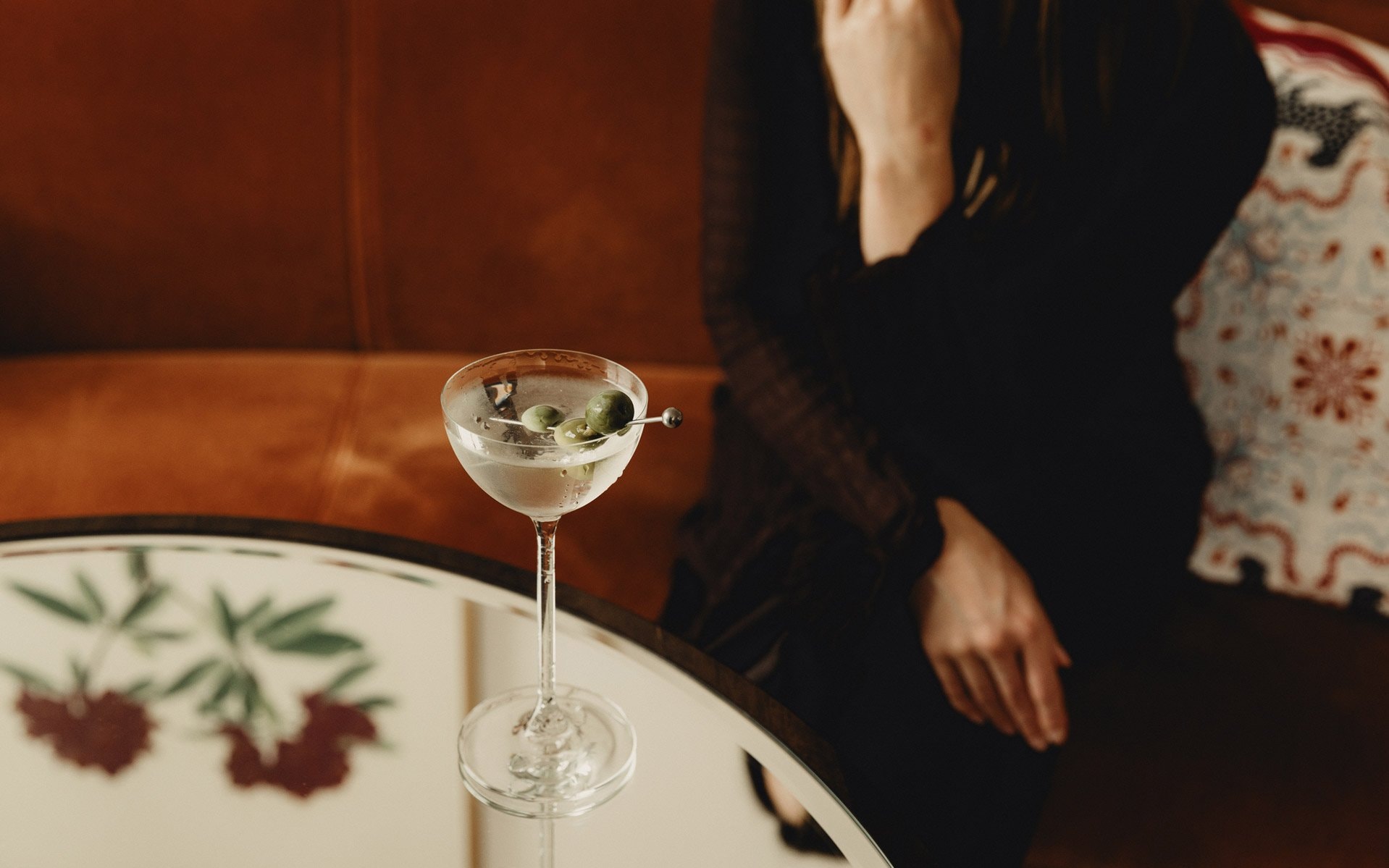 A cocktail garnished with three olives
