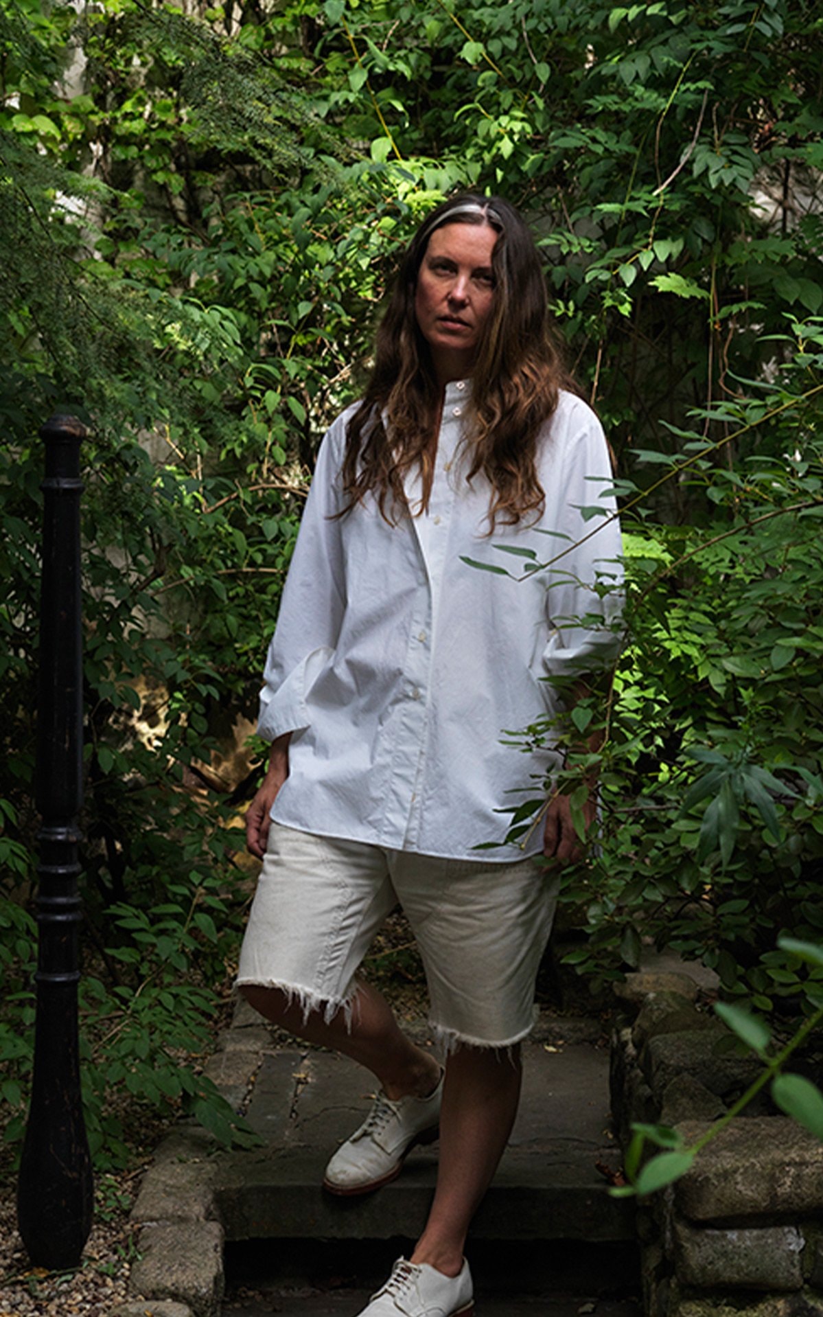 A person posing for a photo standing in a garden