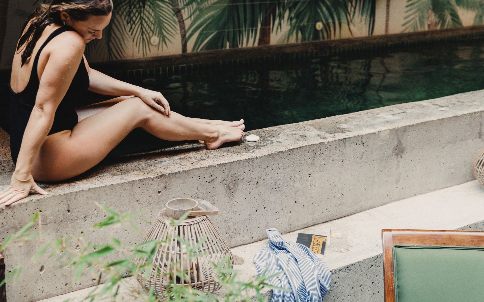 A woman sitting on the edge of a pool
