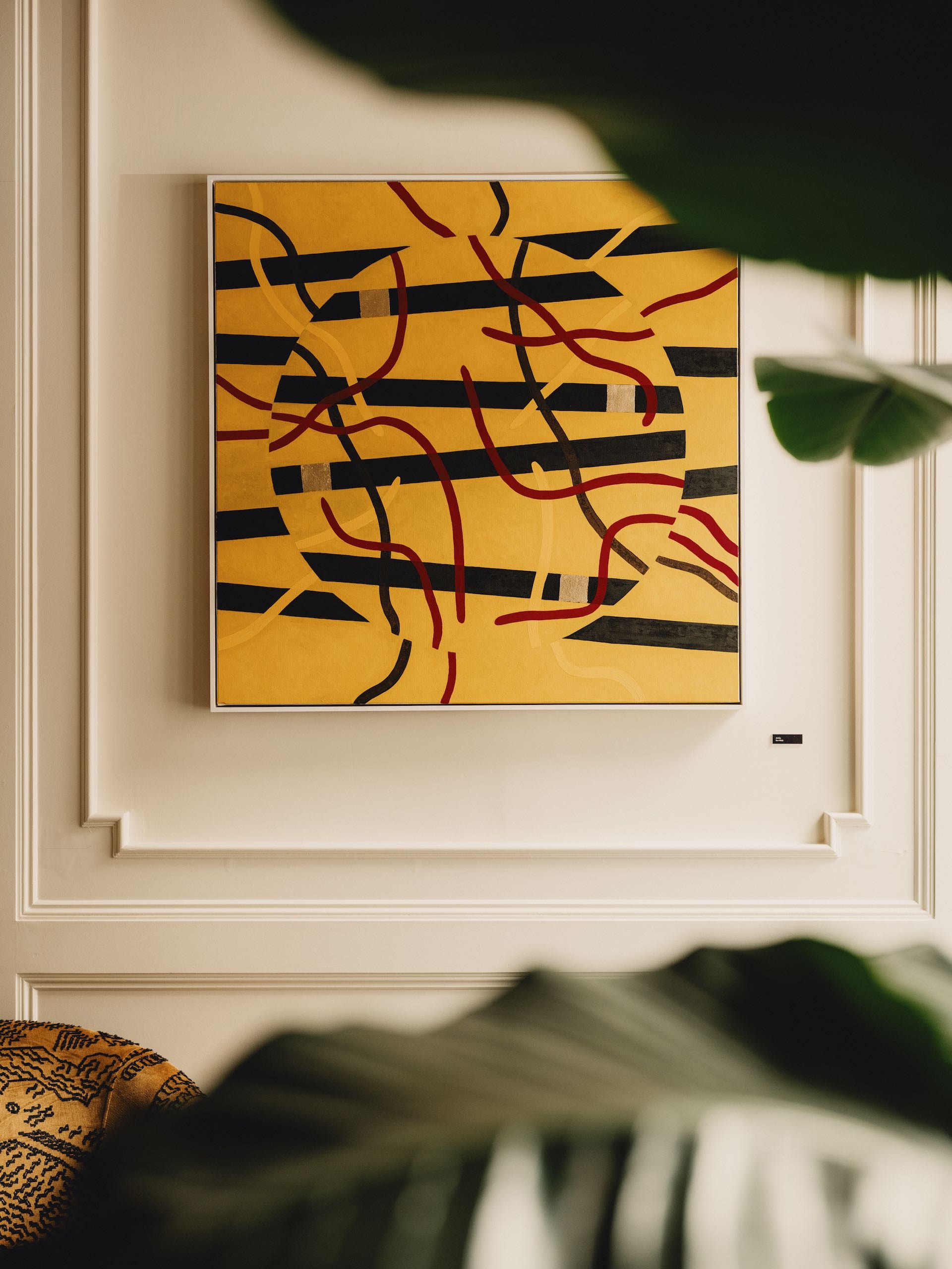 An abstract painting hanging on a white wall